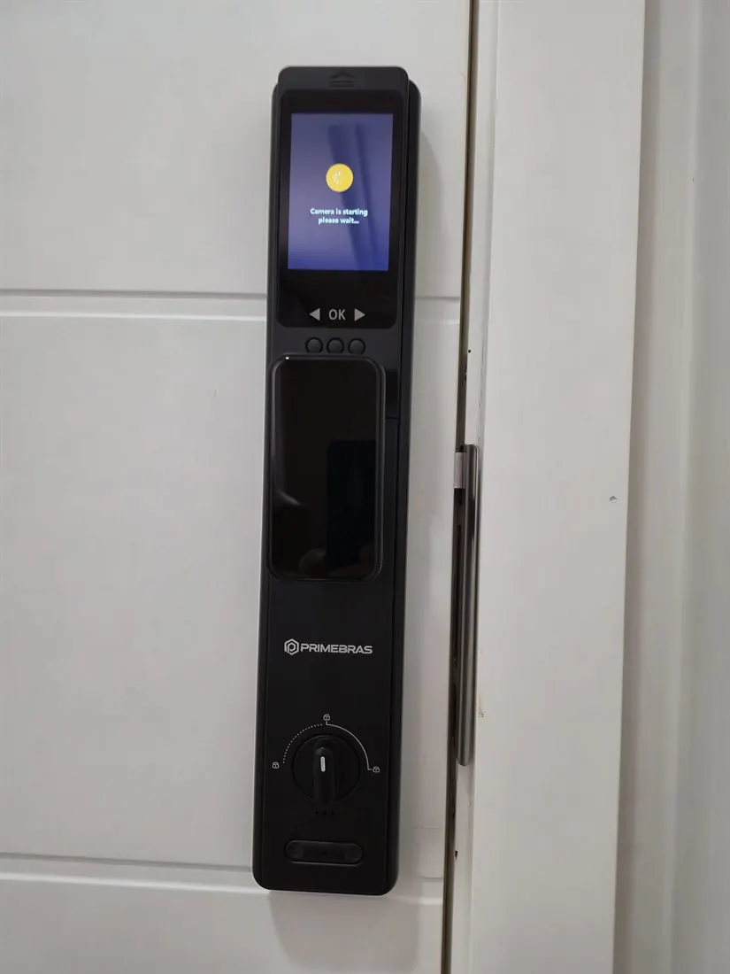 Fechadura digital com reconhecimento facial e tela acesa em porta branca