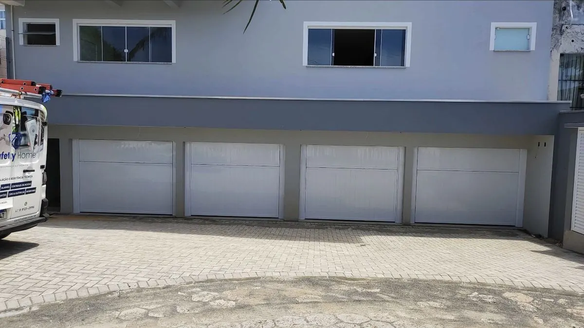 Prédio com quatro portões automáticos de garagem brancos
