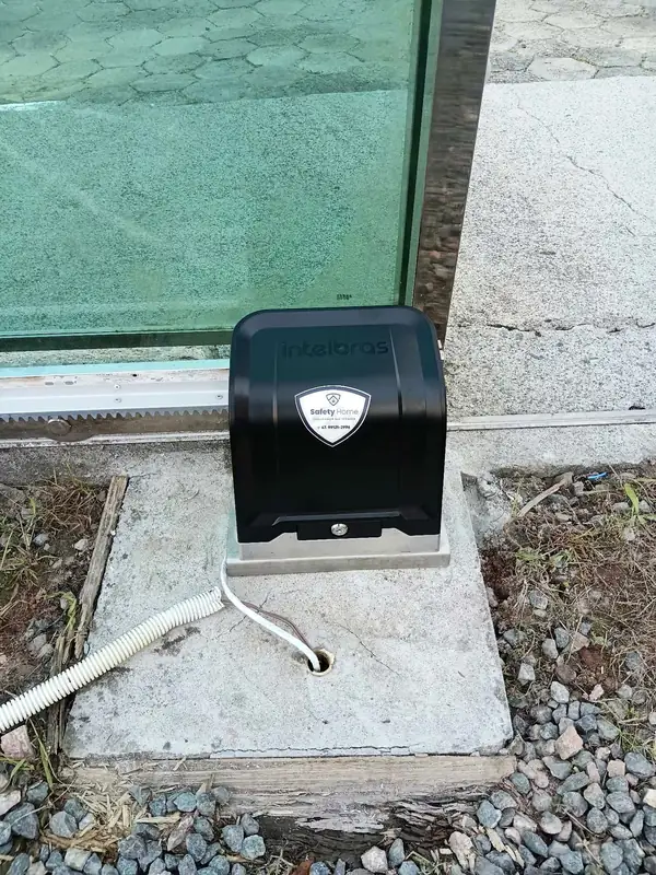 Depois: o mesmo portão com motor novo preto, com o adesivo de escudo da Safety Home